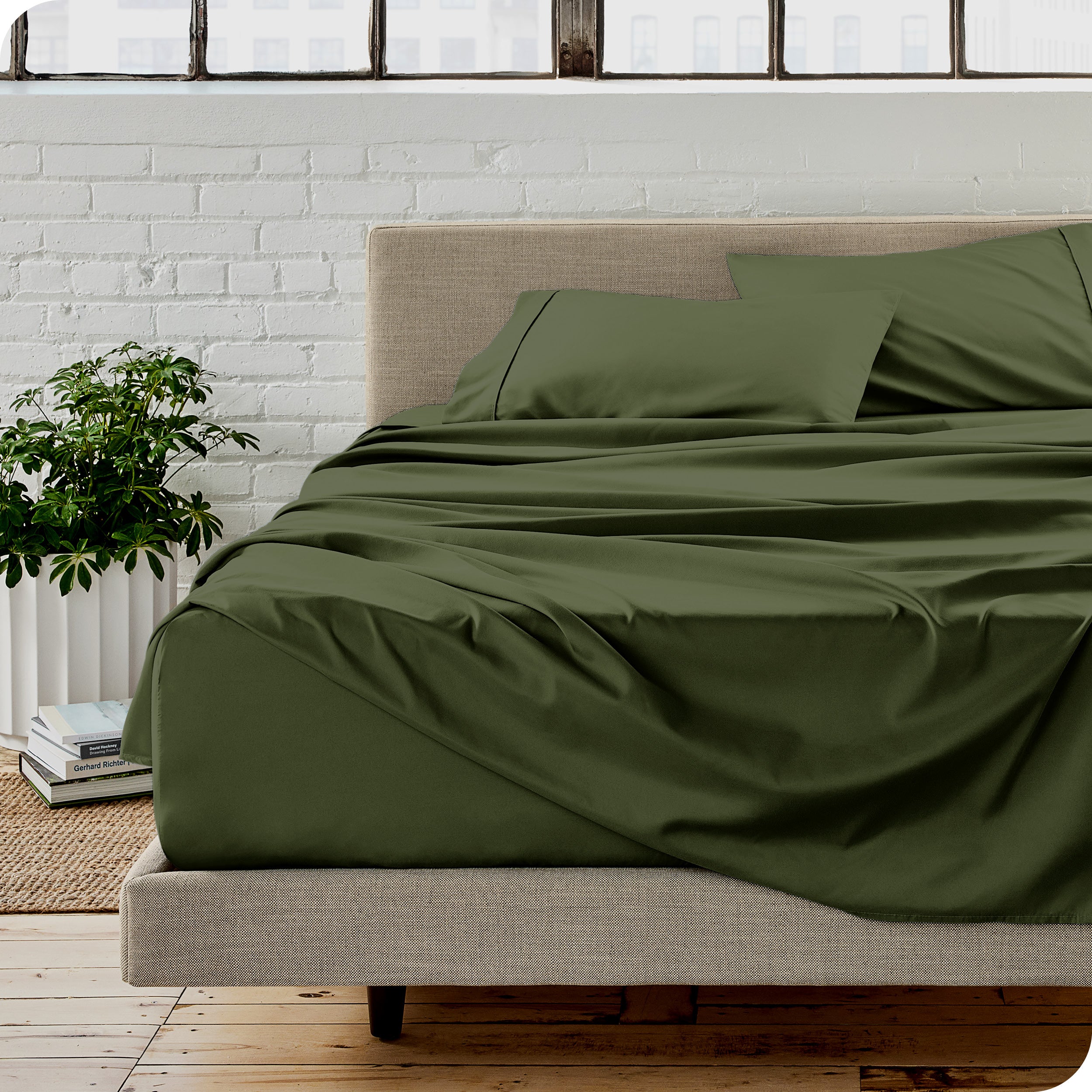 Microfiber sheets on a bed with a brick wall behind it