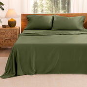 TENCEL™ sheet set on a bed with the flat sheet loosely draped over the top. The mattress is on a wooden bed frame.