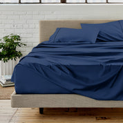 The sheet set with the matched same color pillowcases putting over the bed in a modern room.