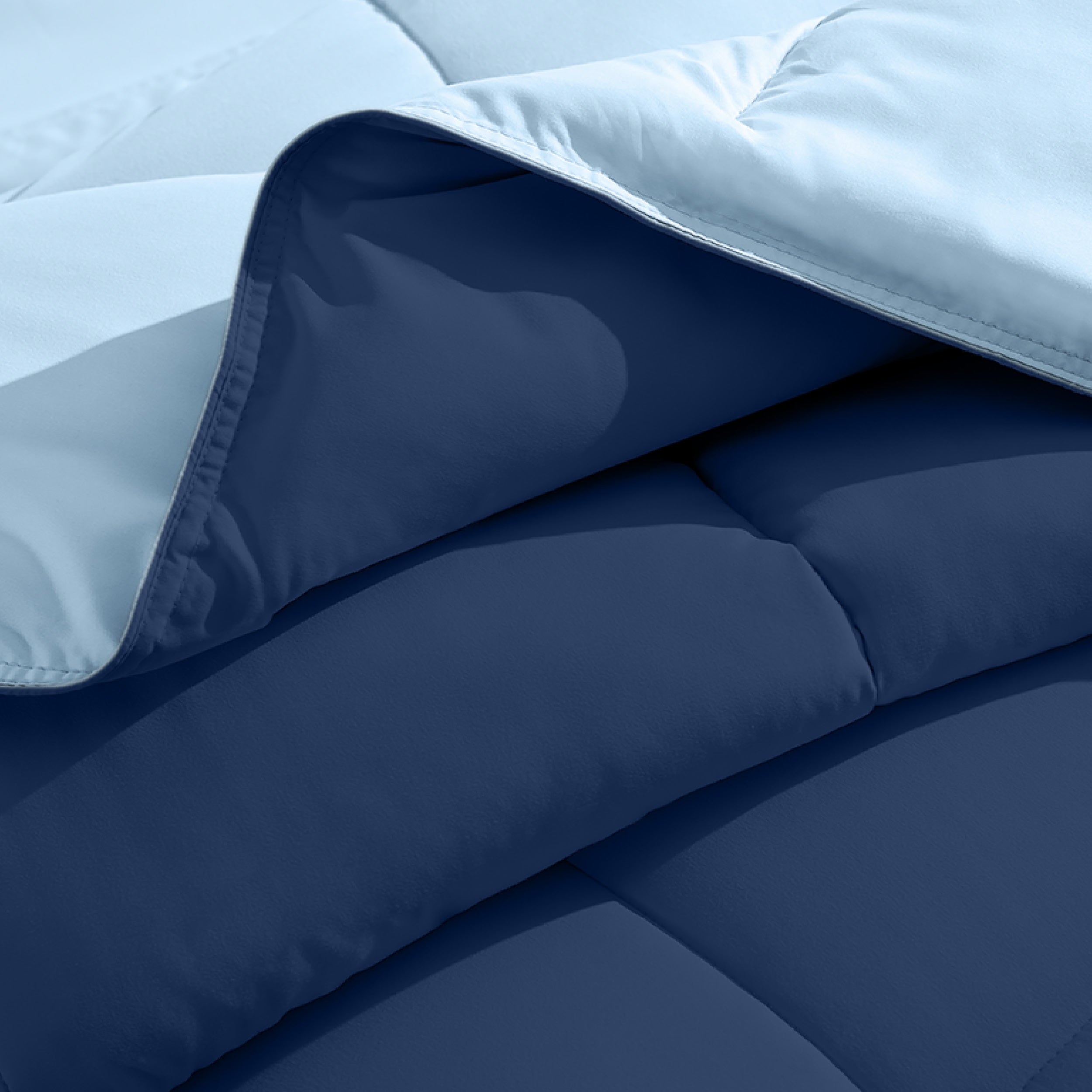Close up of the reversible comforter showing the box stitching and the two colors