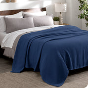 A cotton waffle blanket draped over a bed
