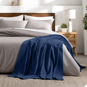 A cotton waffle blanket on the corner of a bed