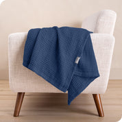 A cotton blanket on the arm of a chair