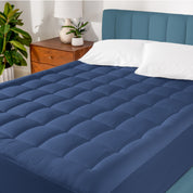 A mattress pad on a bed in a warm bright room.