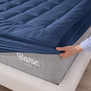 The corner of a mattress with a mattress pad putting on it