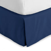 The corner of a bed skirt on a bed frame