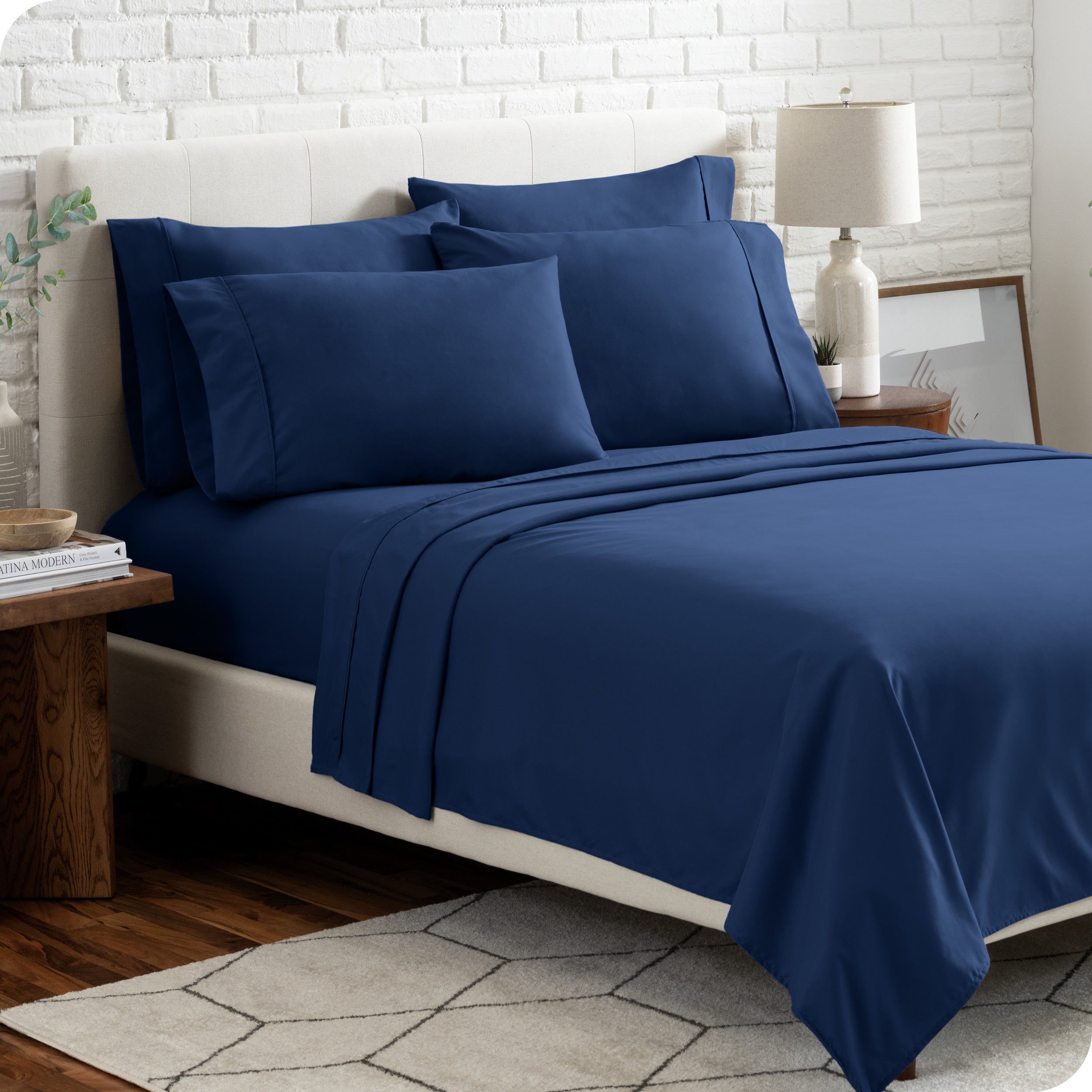 A bedroom setting with a bed made with the microfiber bed sheets and four pillows.