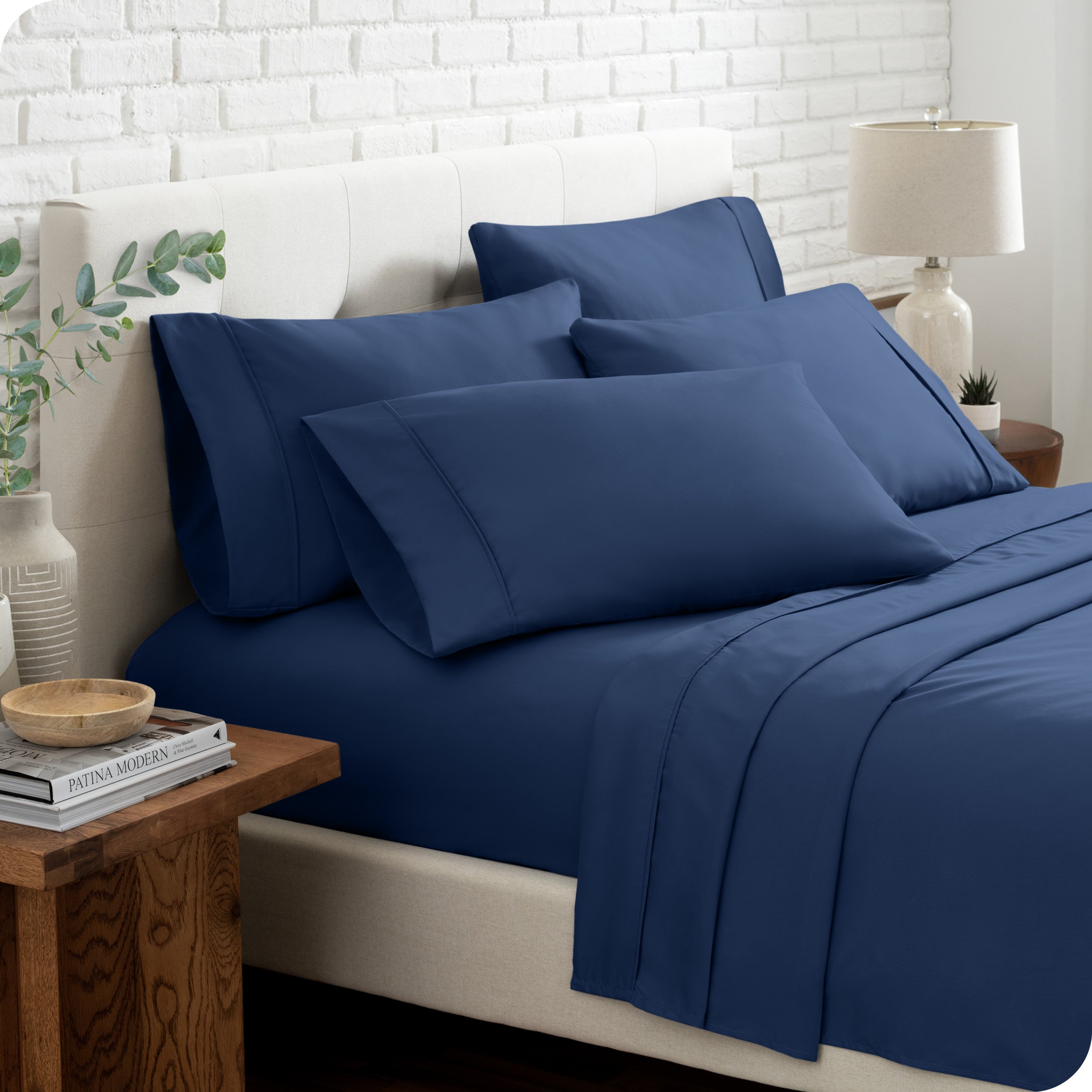 Close up of the microfiber bed sheets on a bed with four pillows.