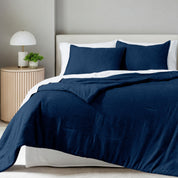 A comforter set on a bed in a bright modern room