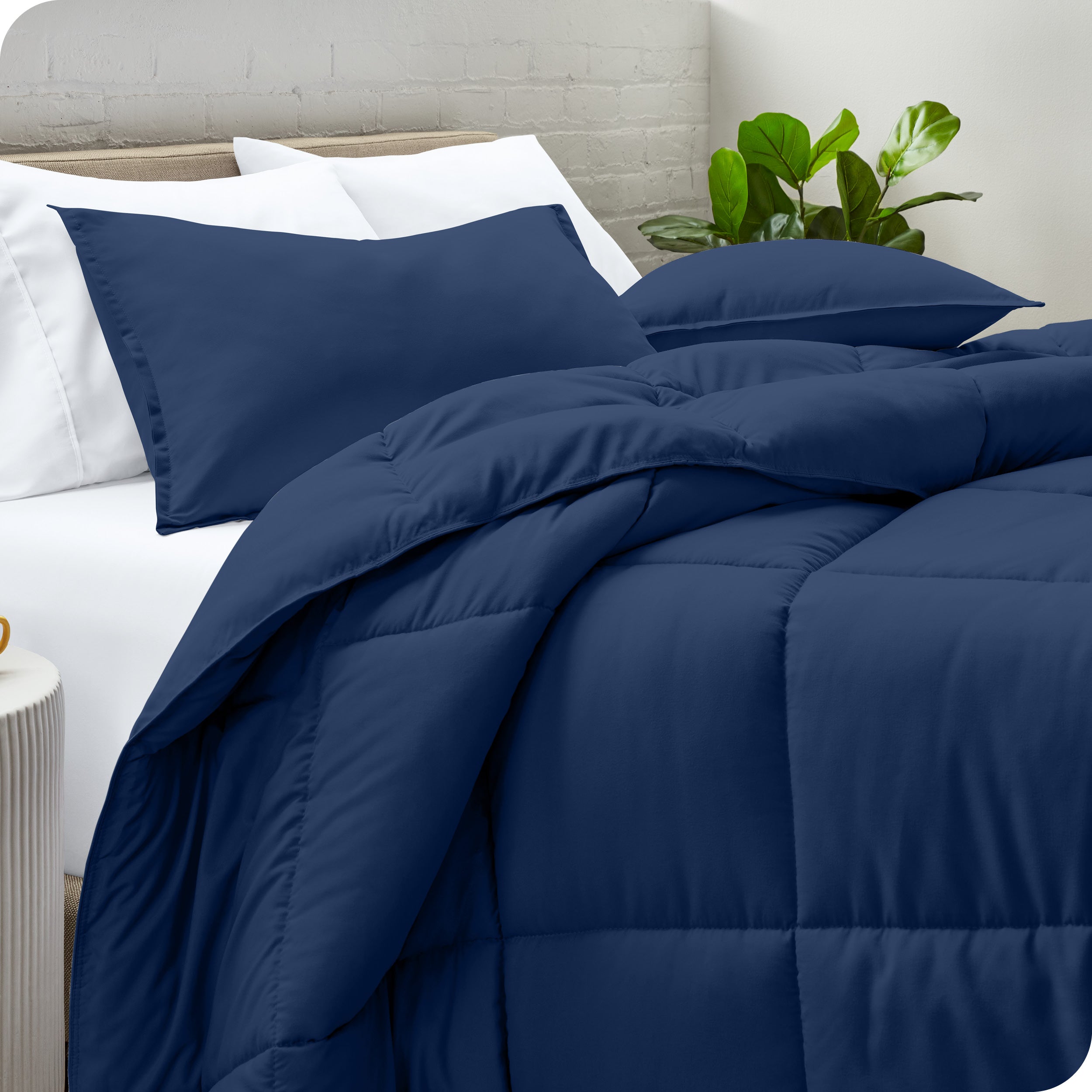 A side view of a modern bed with a comforter set and pillows on the bed