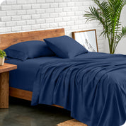 Microfiber sheets and matching pillowcases on a bed next to a large plant
