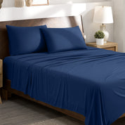 Stretch sheets on a bed with a wooden headboard in a bedroom setting.