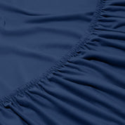 Close-up of a fitted sheet with elastic edge on a bed.