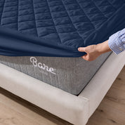 The corner of a mattress with a mattress pad putting on it