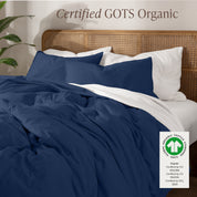 A bed made with an GOTs certified organic jersey duvet cover, pillow sham covered pillows and extra pillows
