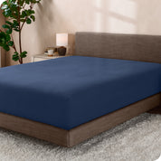 A sideview of a modern bed with a polar fleece fitted sheet on.