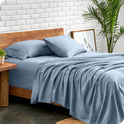 Microfiber sheets and matching pillowcases on a bed next to a large plant