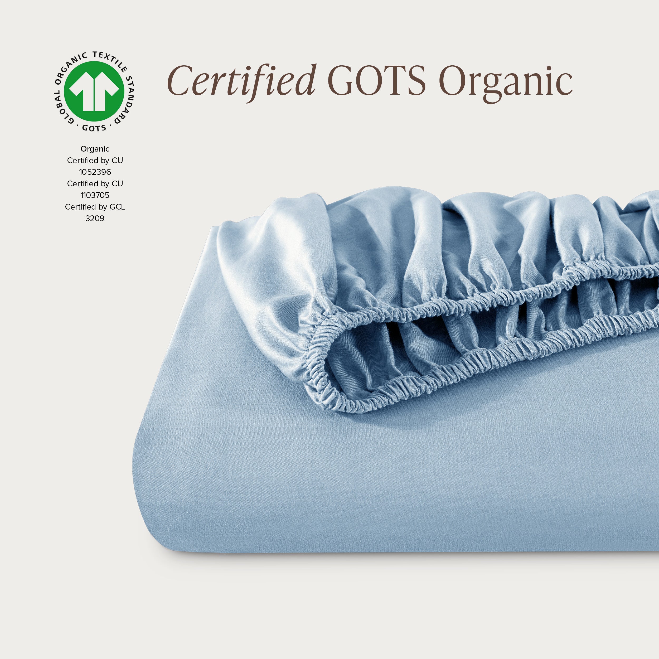 A single fitted sheet folded neatly showing part of the elastic. The fitted sheet is Certified GOTS Organic.