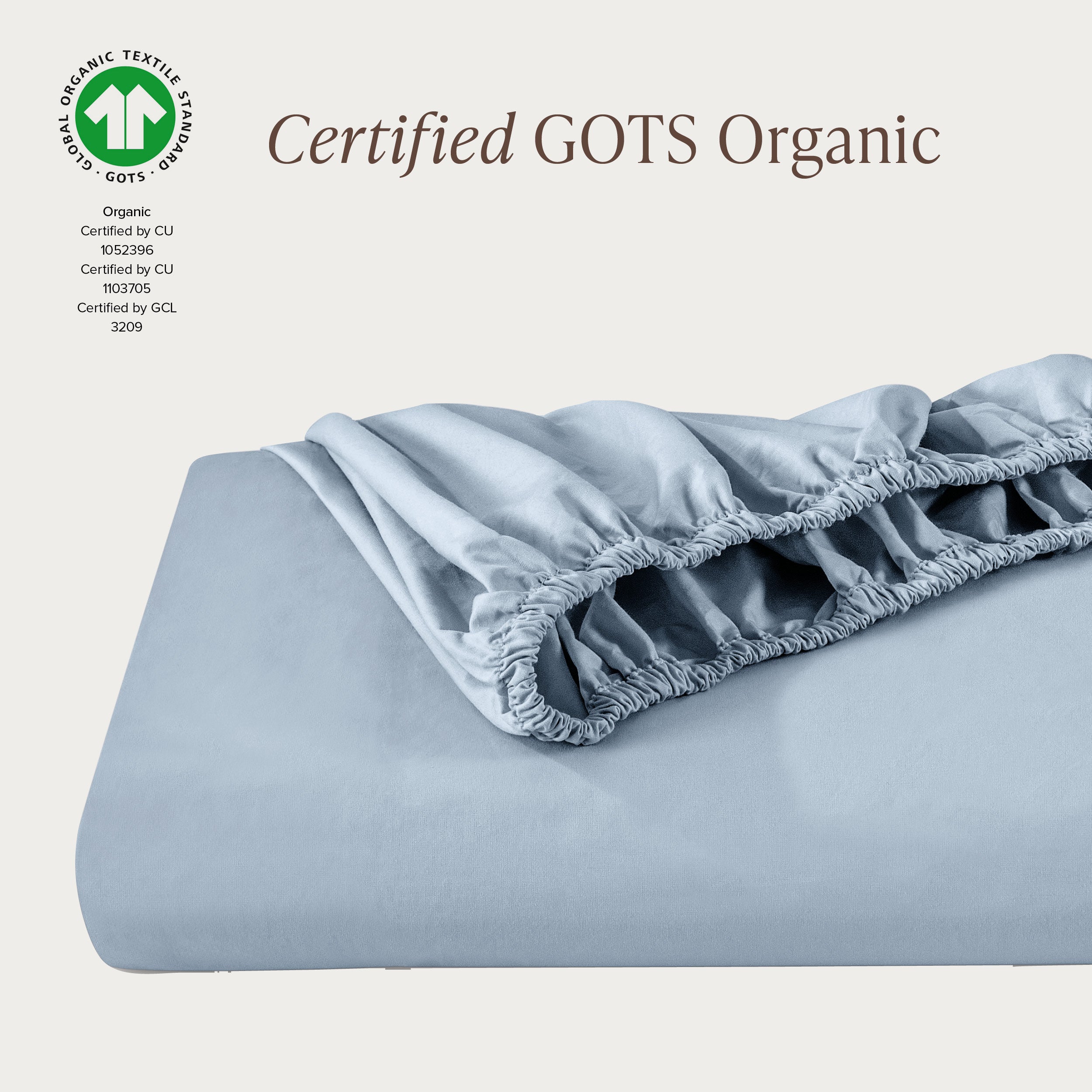 A single fitted sheet folded neatly showing part of the elastic. The fitted sheet is Certified GOTS Organic.
