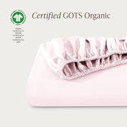 A single fitted sheet folded neatly showing part of the elastic. The fitted sheet is Certified GOTS Organic.