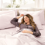 Woman lying in a bed made with organic cotton sheets