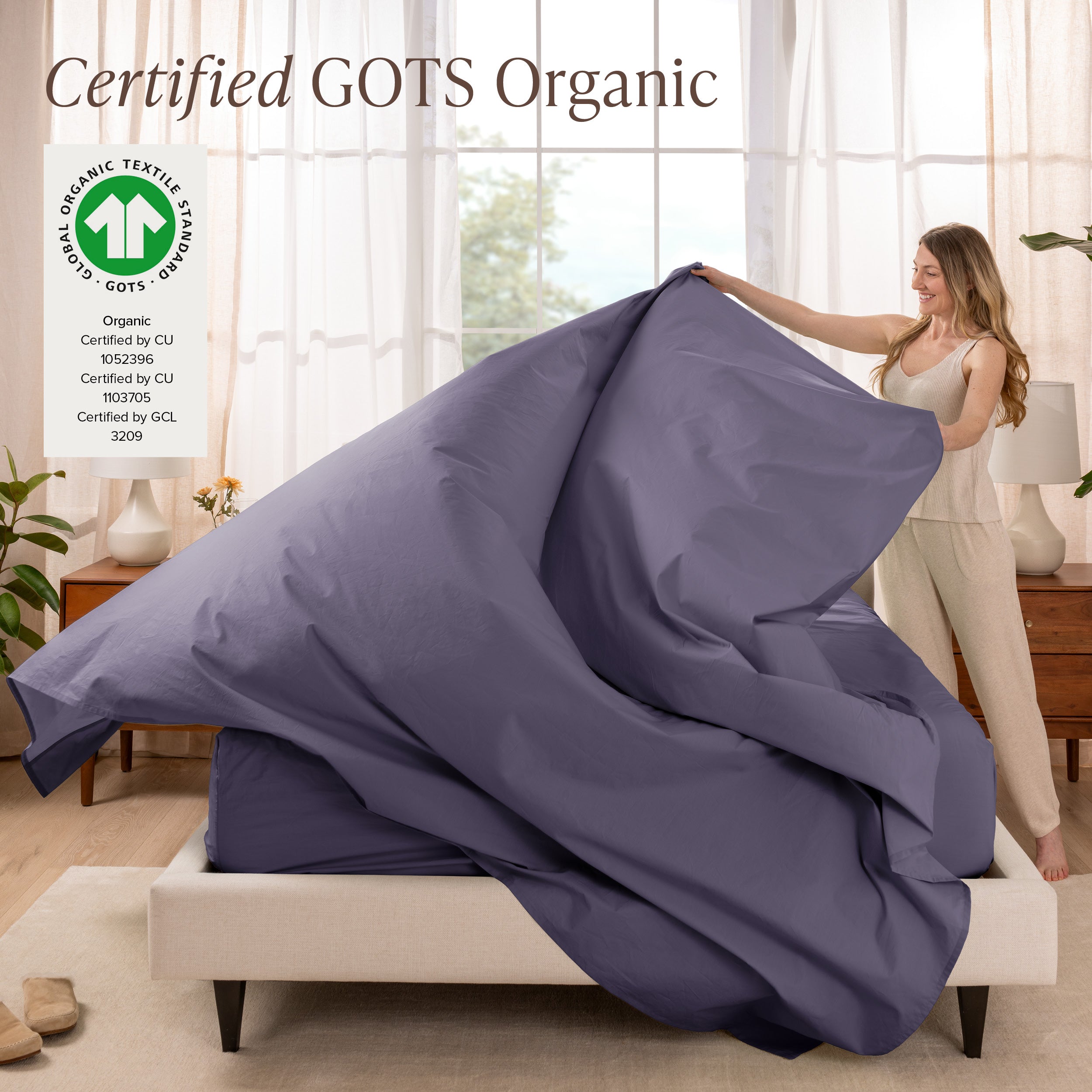 Woman lying in bed under percale sheets with a bright room setting