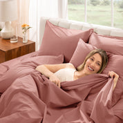 Woman lying in bed under percale sheets with a bright room setting