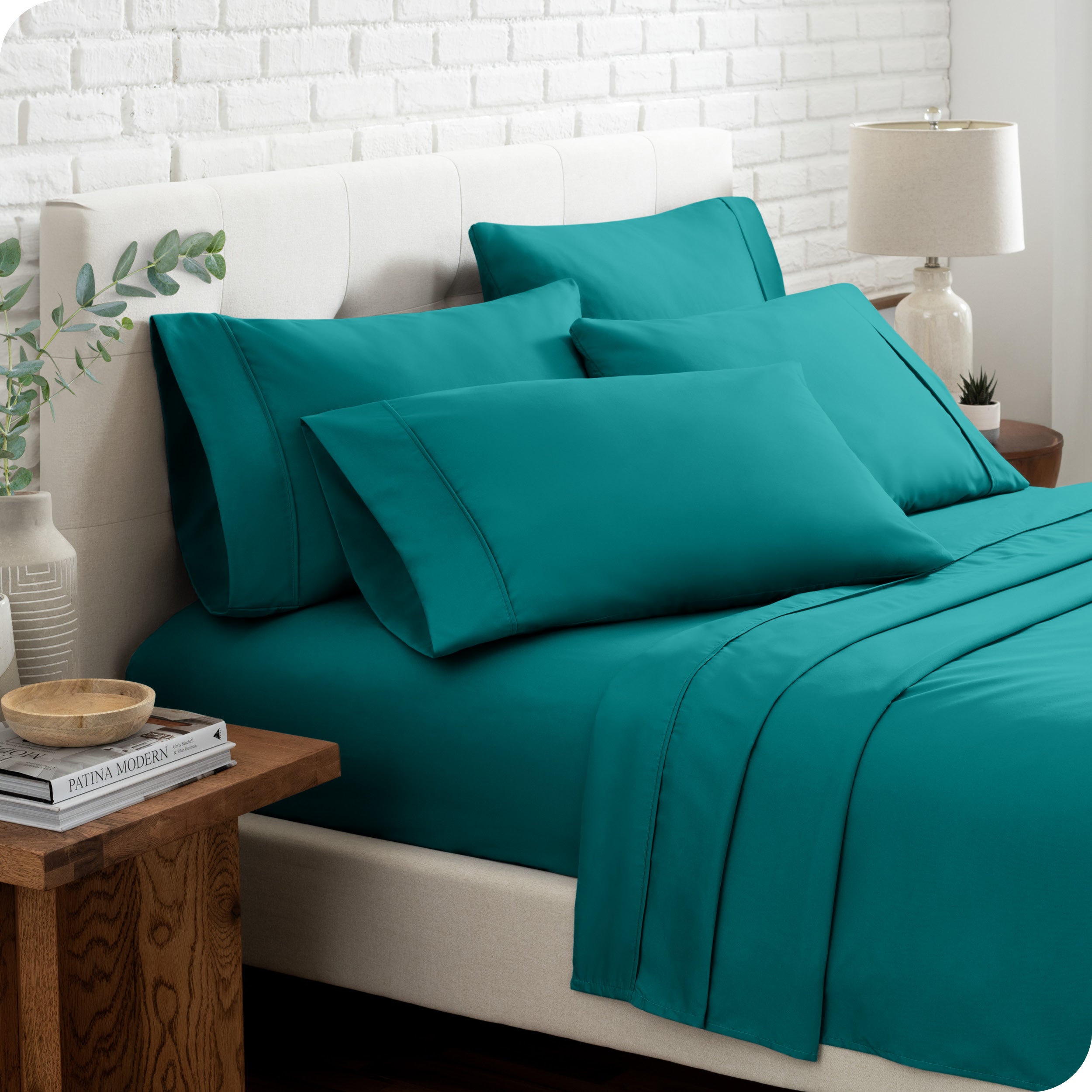 Close up of the microfiber bed sheets on a bed with four pillows.