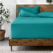 A modern bed with a fitted microfiber sheet made on the mattress.