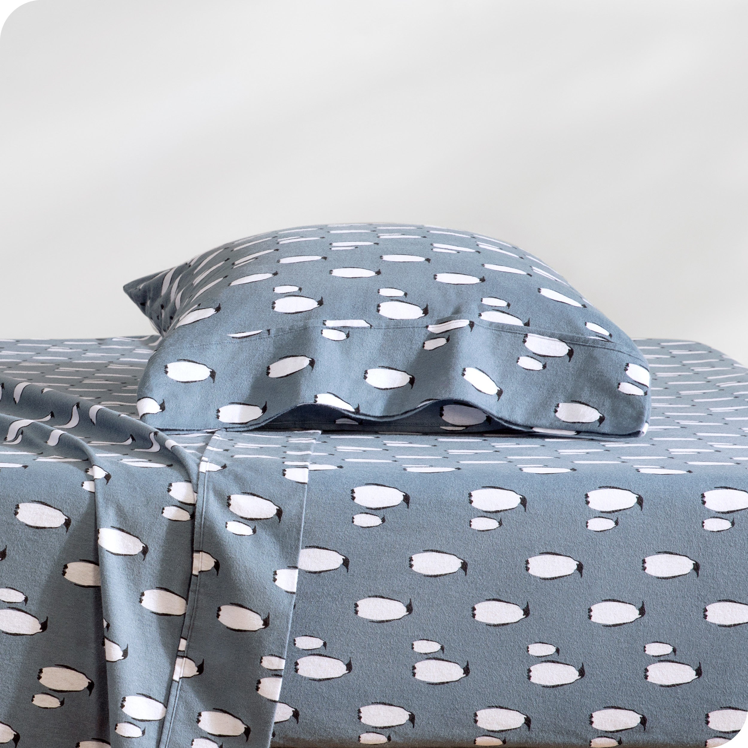 A flannel pillowcase on a pillow set on a bed with matching sheets