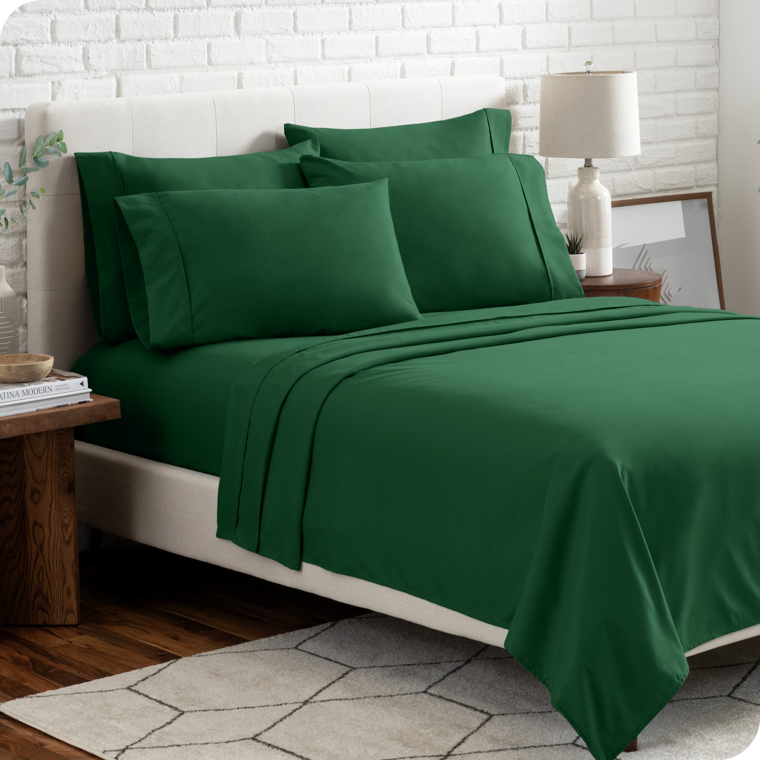 A bedroom setting with a bed made with the microfiber bed sheets and four pillows.