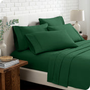 Close up of the microfiber bed sheets on a bed with four pillows.