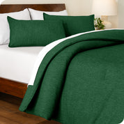 A side view of a bed made with a track stitch comforter set