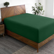A wide corner view of a modern bed made with a microfiber fitted sheet on the mattress.