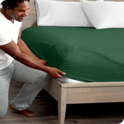 A modern bed with a fitted microfiber sheet on it