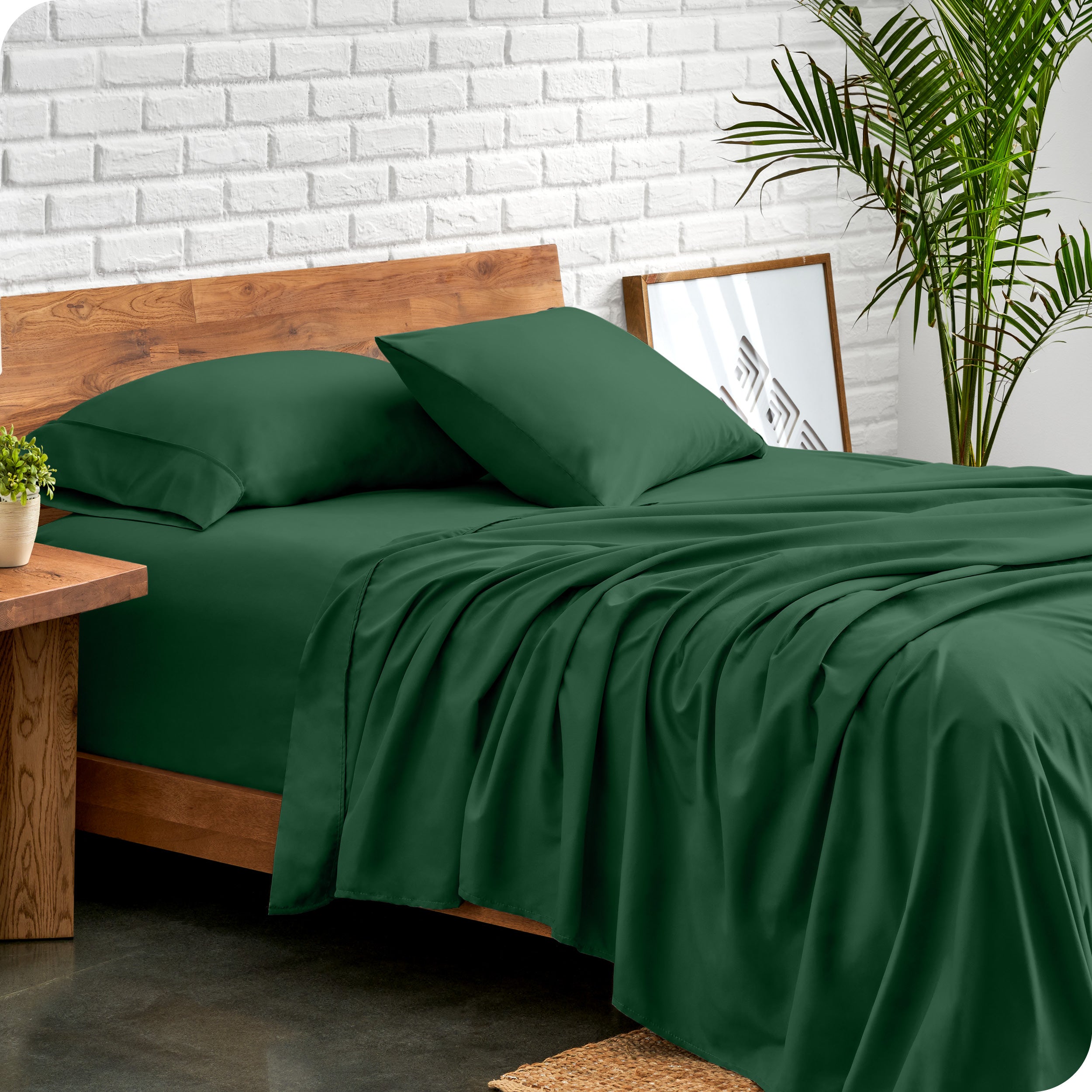 Microfiber sheets and matching pillowcases on a bed next to a large plant