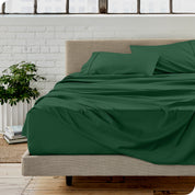 Microfiber sheets on a bed with a brick wall behind it