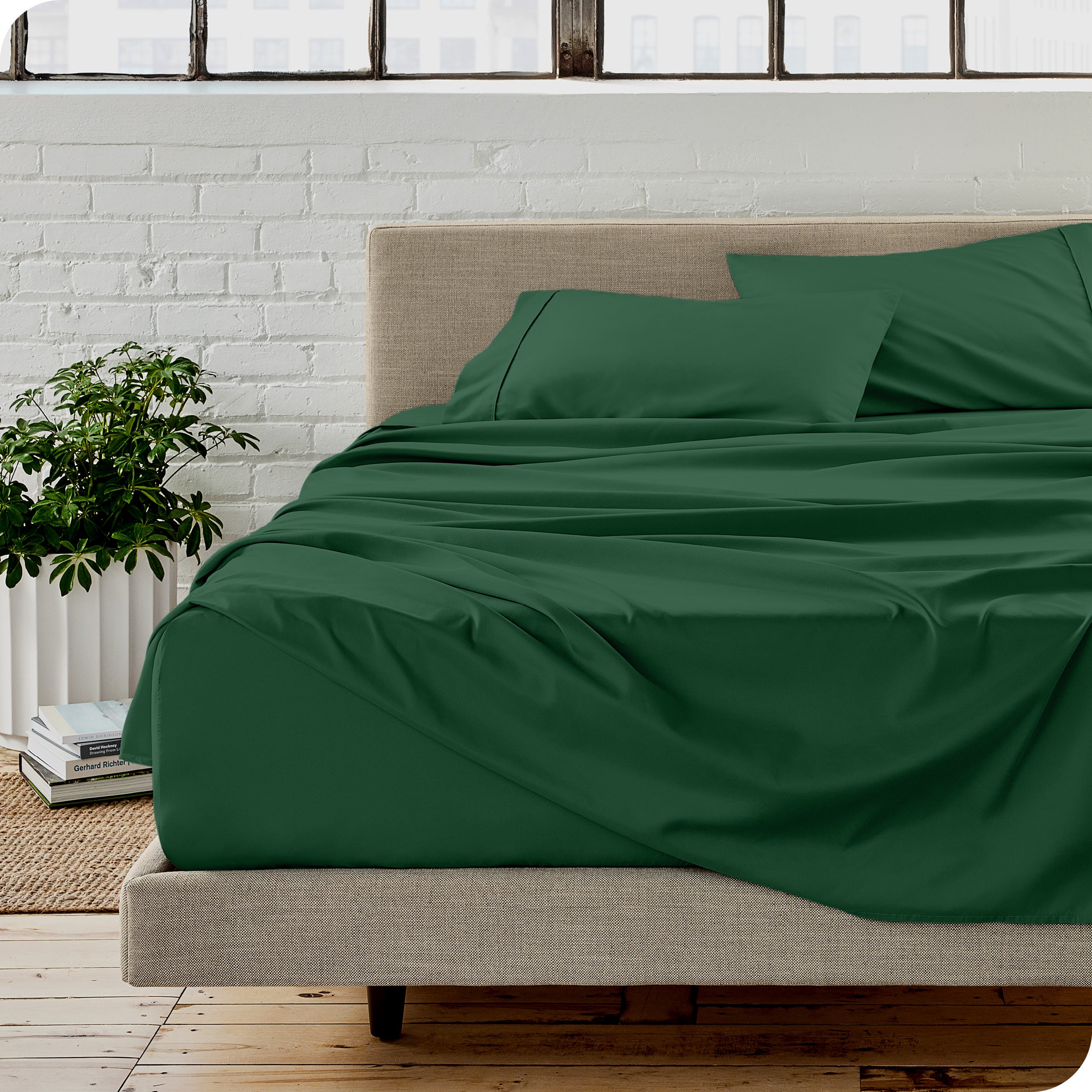 Microfiber sheets on a bed with a brick wall behind it
