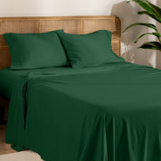 Organic jersey sheets and pillowcases on a bed with plants on the side in a bright and chill room scene.