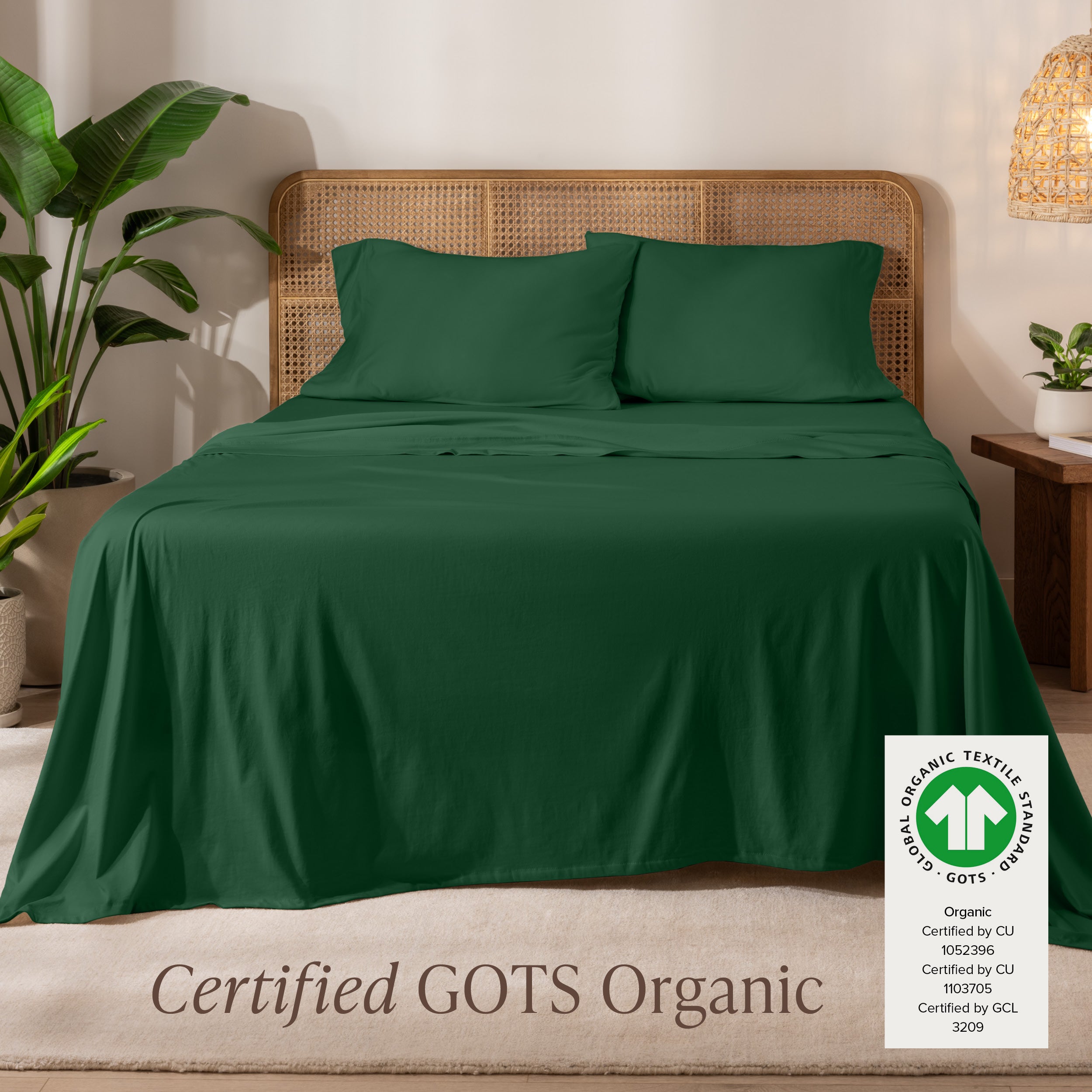 A bed in the middle of room with a set of Certified GOTS Organic Jersey Sheet Set on it.
