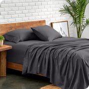 Microfiber sheets and matching pillowcases on a bed next to a large plant