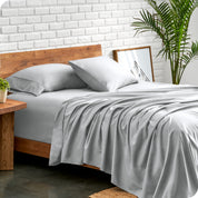Microfiber sheets and matching pillowcases on a bed next to a large plant