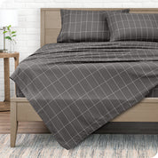 View from the end of a modern bed made with a microfiber sheet set with a modern print.