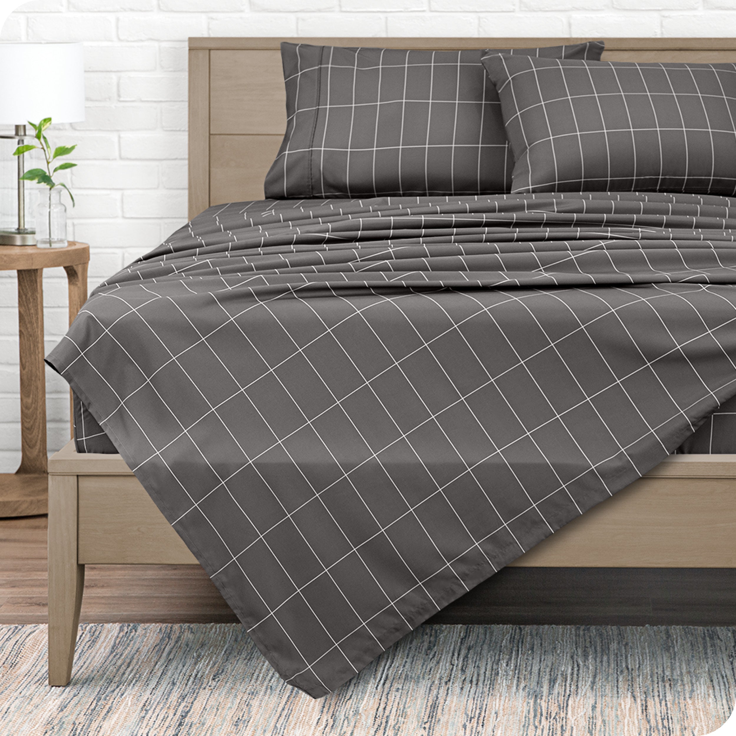 View from the end of a modern bed made with a microfiber sheet set with a modern print.