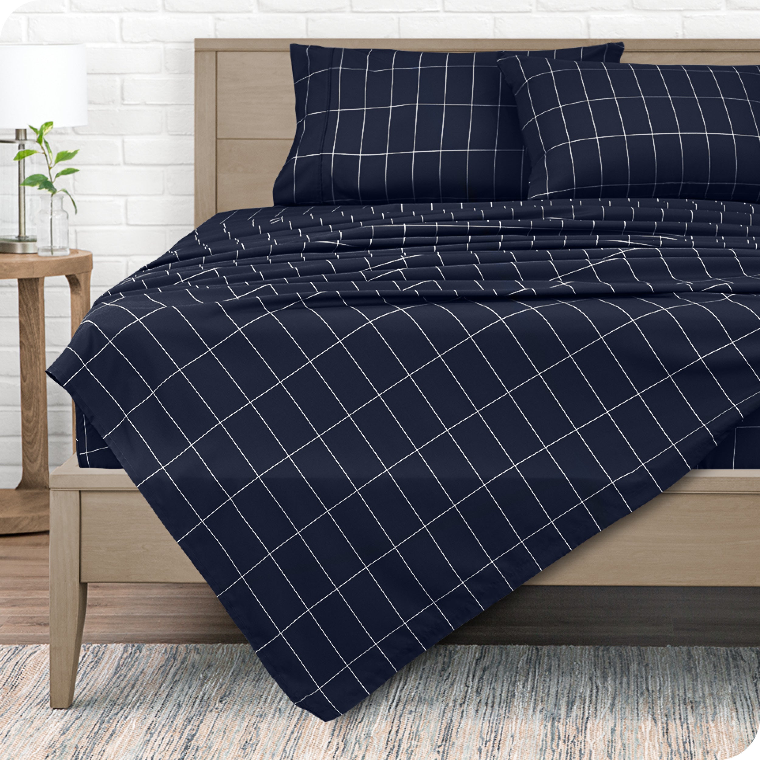 View from the end of a modern bed made with a microfiber sheet set with a modern print.