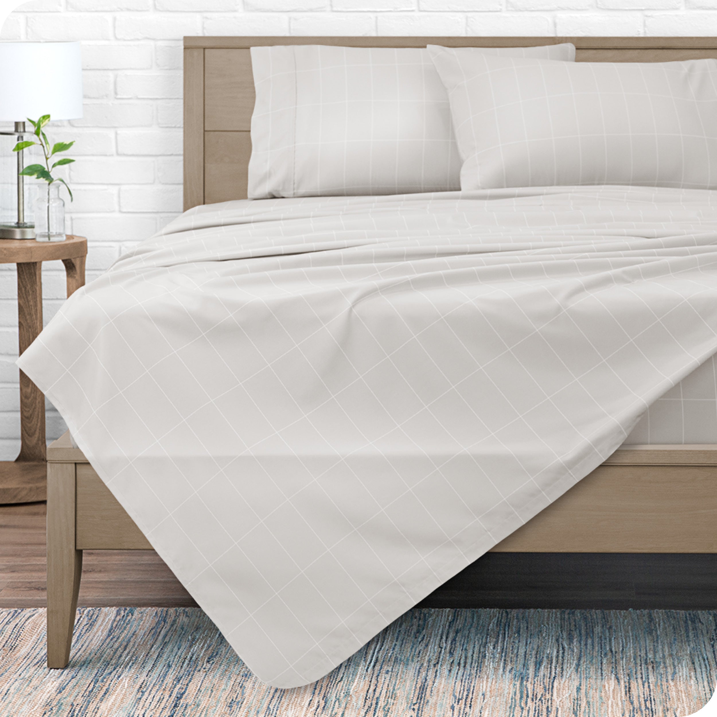 View from the end of a modern bed made with a microfiber sheet set with a modern print.
