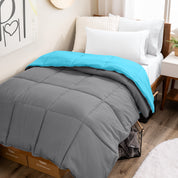 Wooden bed frame with a reversible comforter on the bed. The comforter is folded back over showing the two different colors.