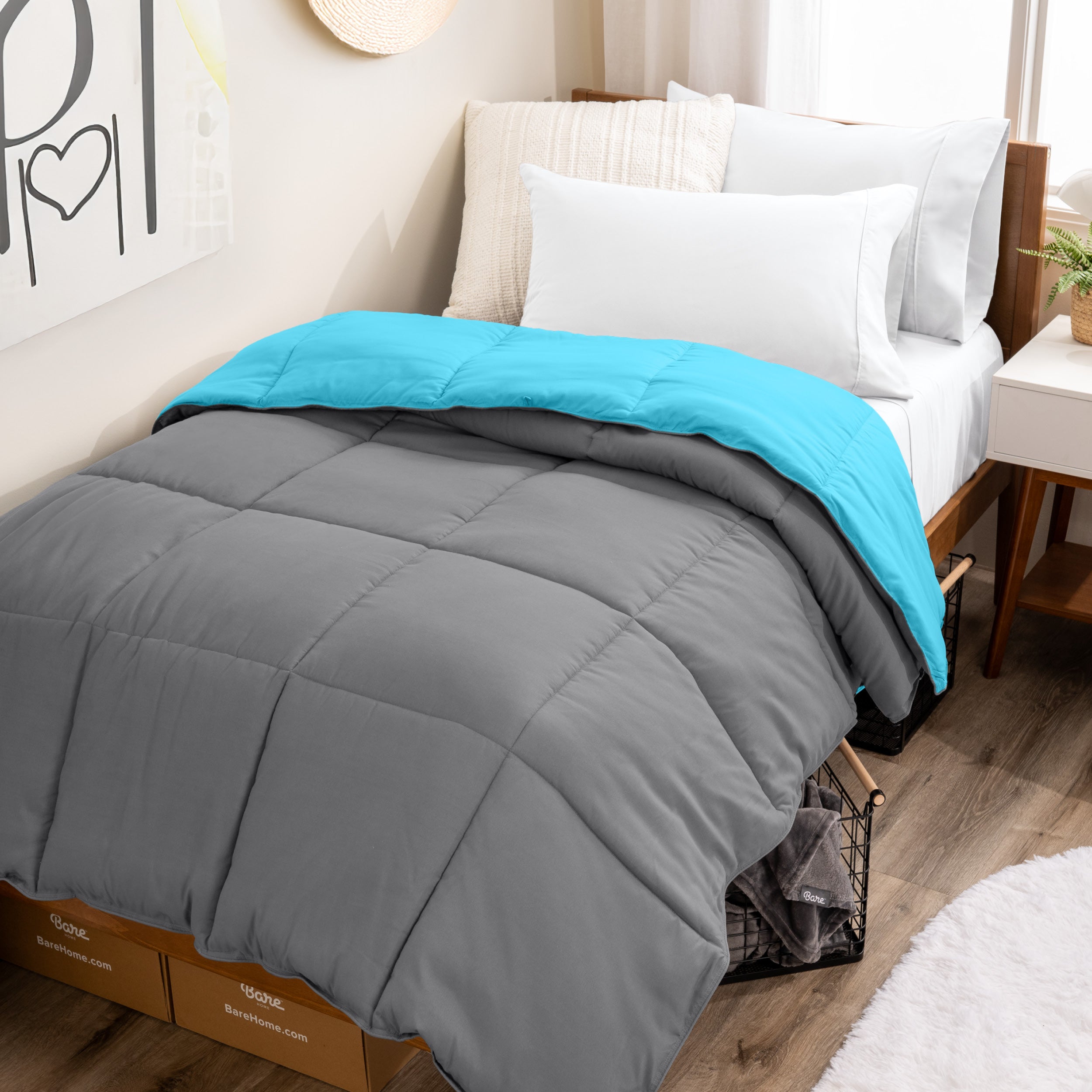 Wooden bed frame with a reversible comforter on the bed. The comforter is folded back over showing the two different colors.