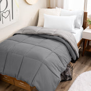 Wooden bed frame with a reversible comforter on the bed. The comforter is folded back over showing the two different colors.