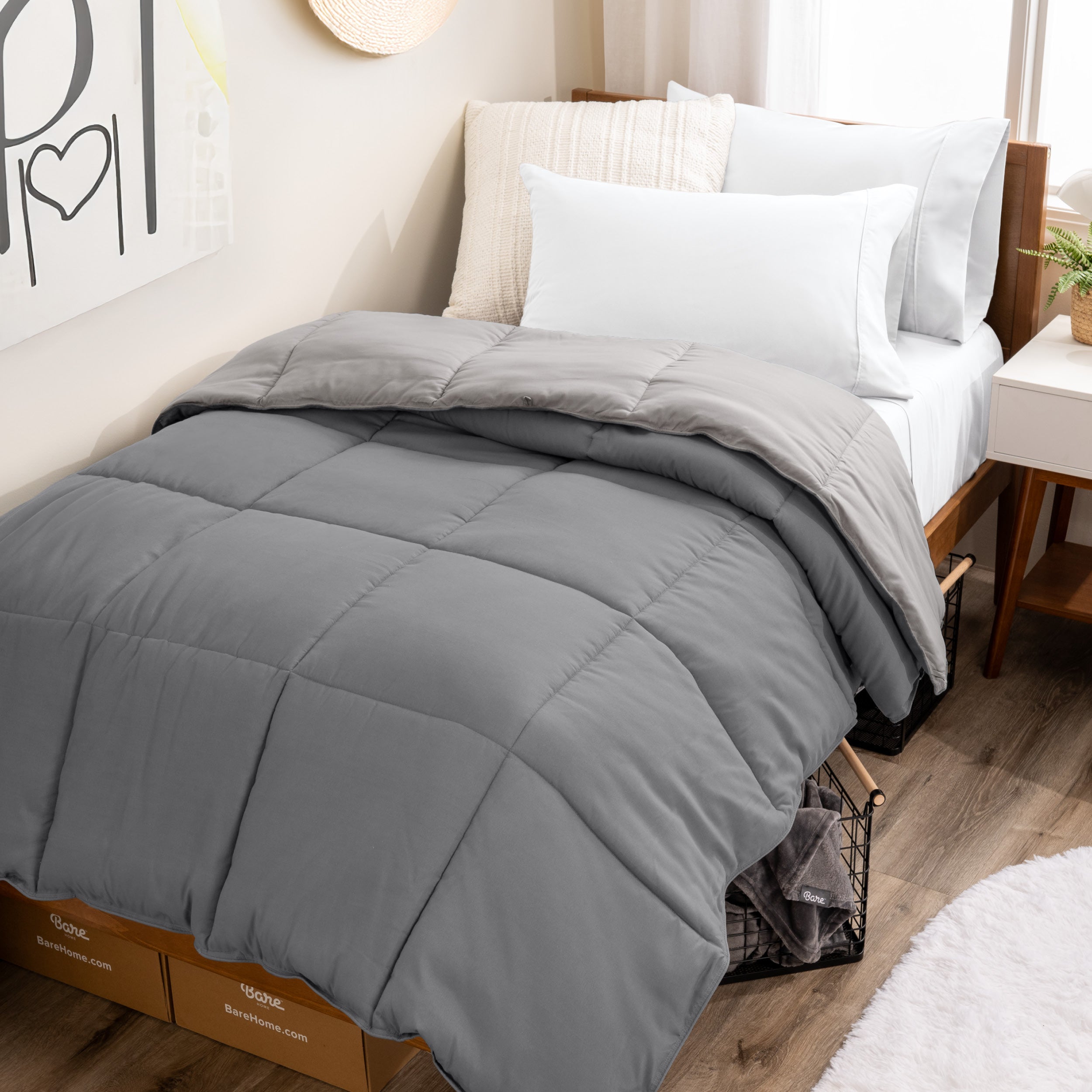 Wooden bed frame with a reversible comforter on the bed. The comforter is folded back over showing the two different colors.